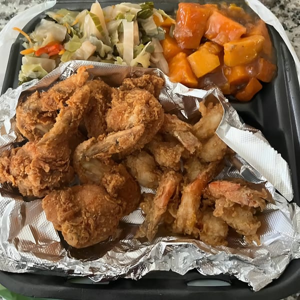 Victoria's Kitchen soul food meal with fried chicken, fried shrimp, cabbage, and candied yams.